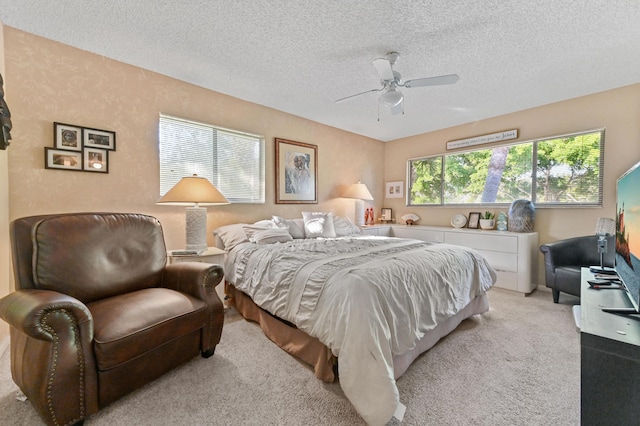 carpeted bedroom featuring a textured ceiling and ceiling fan