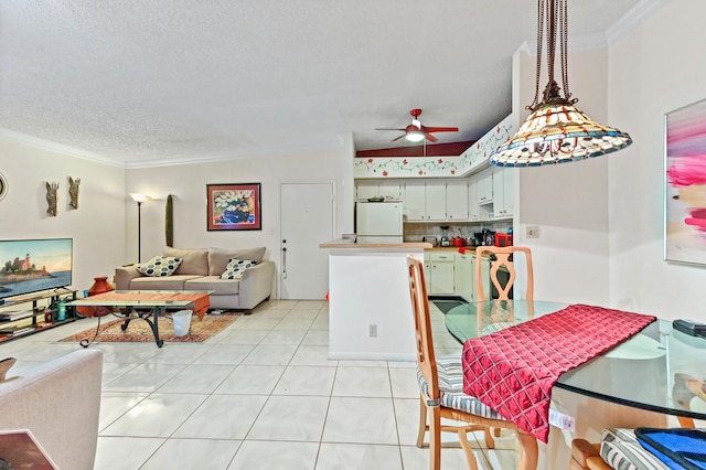 tiled dining area featuring ceiling fan, crown molding, and a textured ceiling