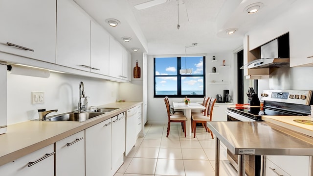 kitchen with dishwasher, sink, light tile patterned flooring, stainless steel electric range, and white cabinets