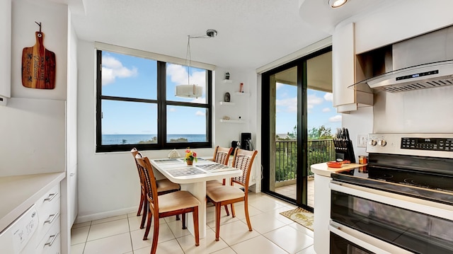 dining area featuring light tile patterned flooring and a water view