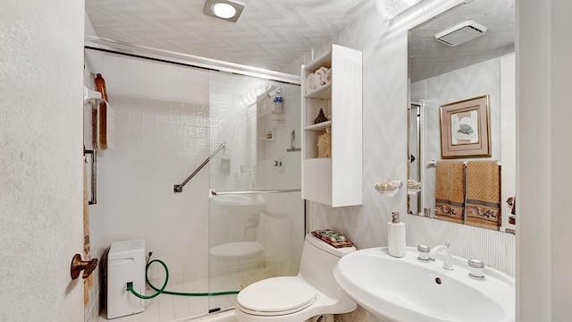 bathroom with walk in shower, sink, and toilet