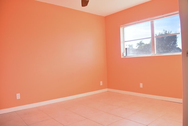 tiled empty room featuring ceiling fan