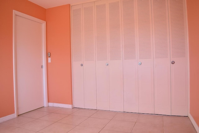 unfurnished bedroom featuring light tile patterned flooring and a closet