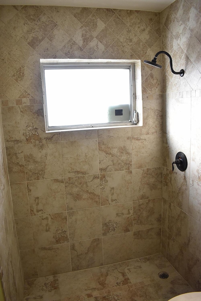 bathroom featuring tiled shower and a wealth of natural light