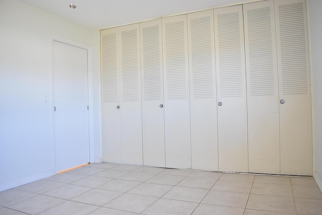 interior space with a closet and light tile patterned flooring