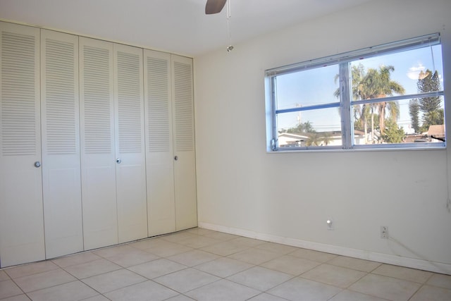 unfurnished bedroom featuring a closet, ceiling fan, and light tile patterned flooring