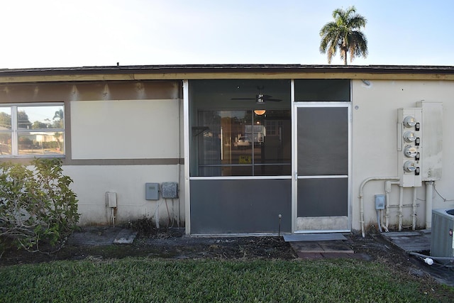 back of property with central AC and a sunroom