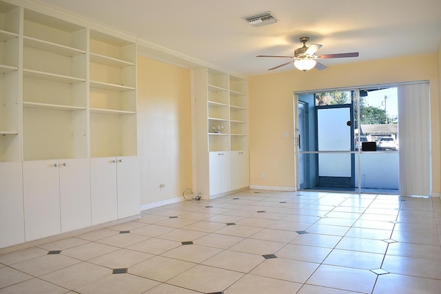 tiled empty room with built in shelves and ceiling fan