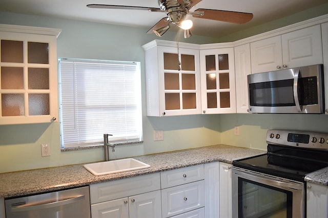 kitchen with ceiling fan, white cabinetry, sink, and appliances with stainless steel finishes