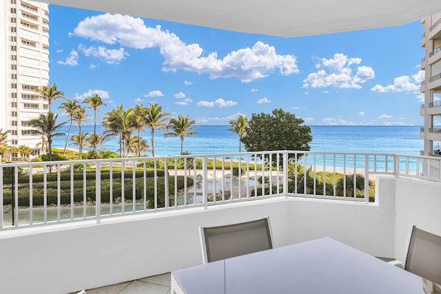 balcony featuring a water view and a view of the beach