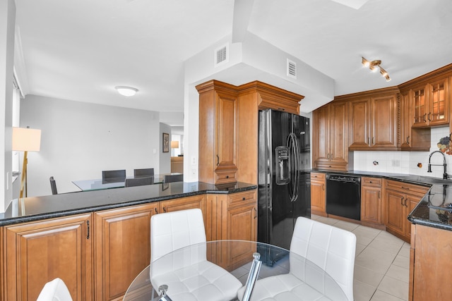 kitchen featuring sink, backsplash, kitchen peninsula, dark stone counters, and black appliances