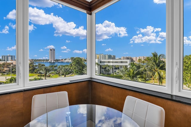 sunroom featuring a water view