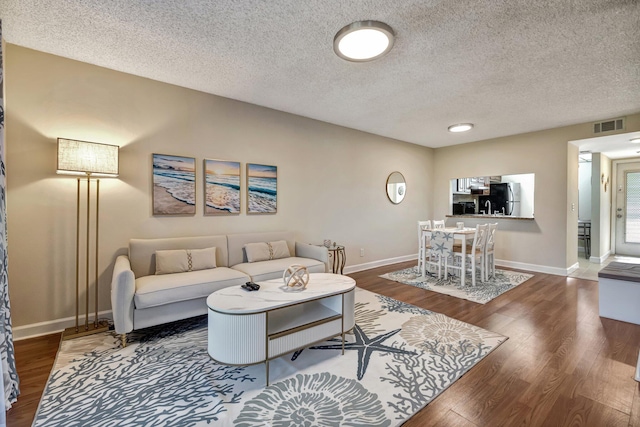 living room with hardwood / wood-style floors and a textured ceiling