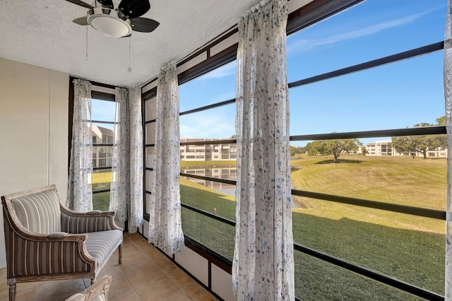 unfurnished sunroom with ceiling fan