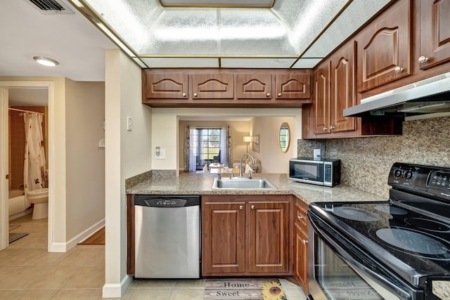 kitchen featuring tasteful backsplash, sink, light tile patterned flooring, and stainless steel appliances