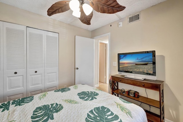 bedroom with ceiling fan, a textured ceiling, and a closet