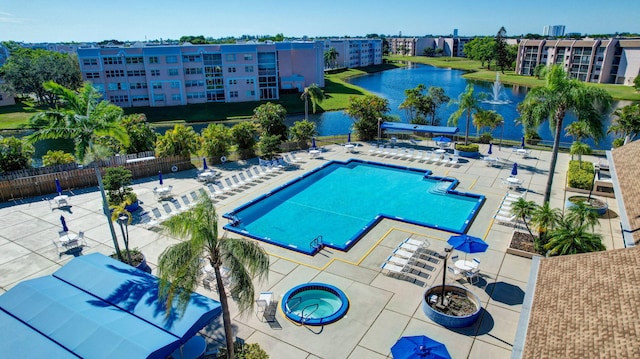 view of swimming pool featuring a community hot tub, a water view, and a patio area