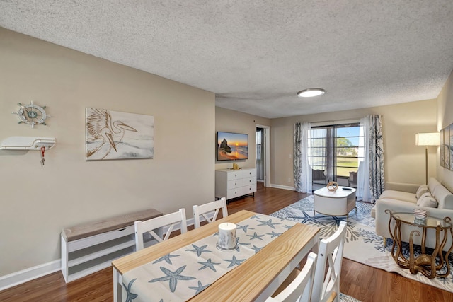 dining room featuring a textured ceiling and dark hardwood / wood-style floors