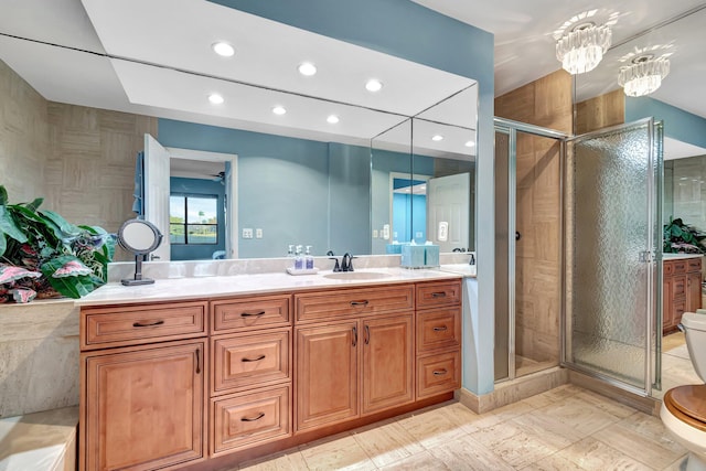 bathroom featuring vanity, toilet, and a shower with shower door