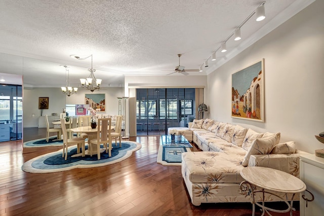 living room featuring wood-type flooring, ceiling fan with notable chandelier, a textured ceiling, and crown molding