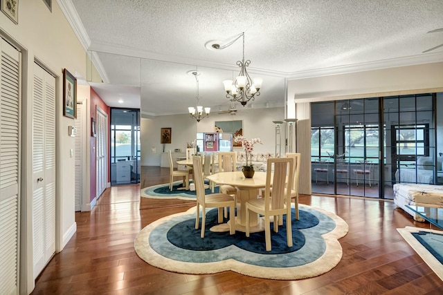 dining area featuring hardwood / wood-style floors, crown molding, a textured ceiling, and a chandelier