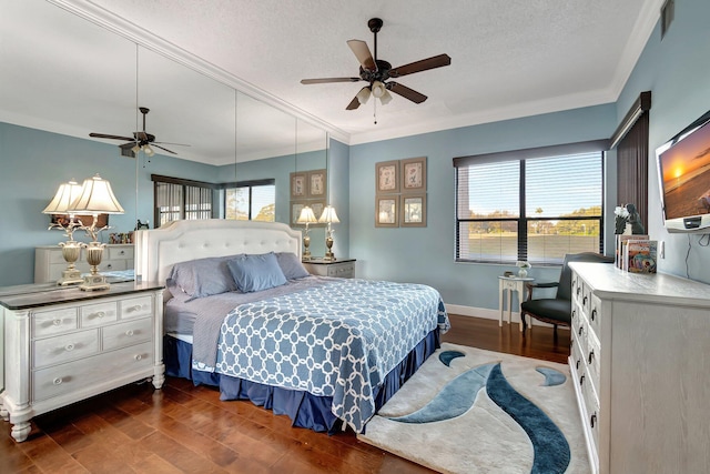 bedroom with ceiling fan, dark hardwood / wood-style floors, ornamental molding, and a textured ceiling