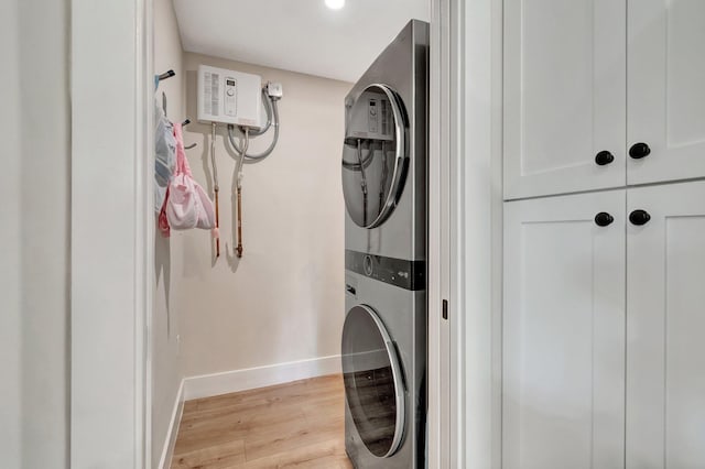 laundry area with stacked washer and dryer and light hardwood / wood-style floors