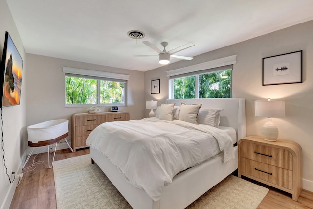 bedroom with light hardwood / wood-style flooring and ceiling fan