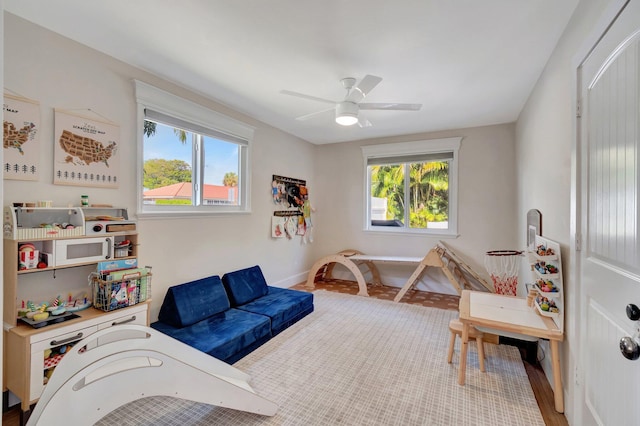 rec room with hardwood / wood-style floors, a wealth of natural light, and ceiling fan