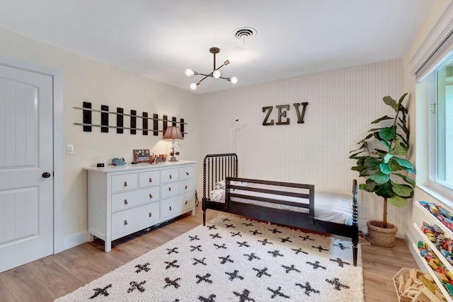 bedroom featuring light hardwood / wood-style floors and an inviting chandelier