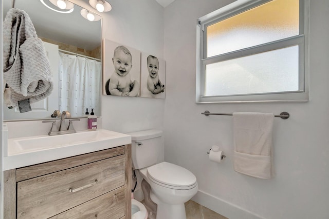 bathroom featuring a shower with curtain, vanity, and toilet