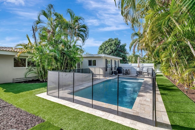 view of swimming pool featuring a lawn and a patio area