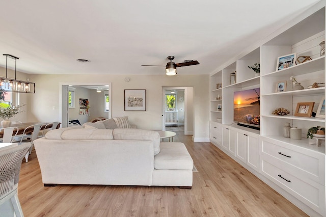 living room with ceiling fan, light wood-type flooring, and a wealth of natural light