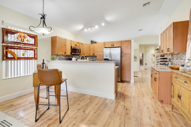 7708 Cherry Blossom Way, Boynton Beach, FL 33437 - kitchen with appliances with stainless steel finishes, vaulted ceiling, backsplash, light wood finished floors, and a peninsula