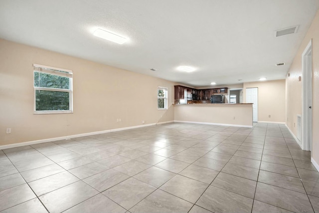 unfurnished living room with a healthy amount of sunlight and light tile patterned flooring