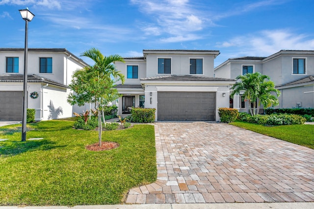 view of property with a garage and a front lawn