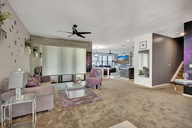 living room featuring ceiling fan with notable chandelier, a textured ceiling, and carpet floors