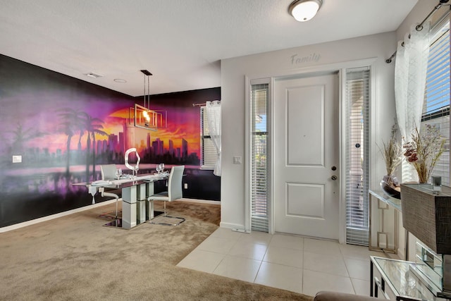 entryway with light carpet and a textured ceiling