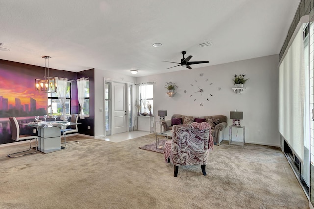 living room featuring ceiling fan with notable chandelier and light colored carpet