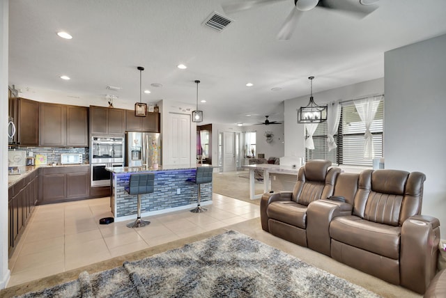 living room with light tile patterned floors and ceiling fan with notable chandelier