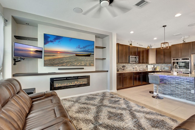 living room with ceiling fan, light tile patterned flooring, and built in features