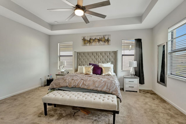 bedroom featuring ceiling fan, light colored carpet, and multiple windows