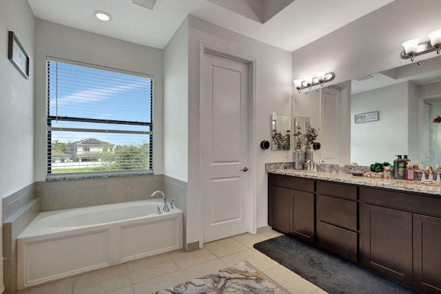 bathroom with tile patterned flooring, vanity, and a tub