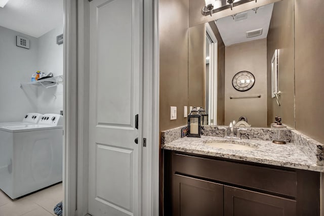 bathroom featuring washer and dryer, vanity, and tile patterned floors