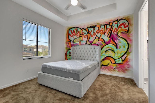 bedroom featuring carpet floors, a raised ceiling, and ceiling fan