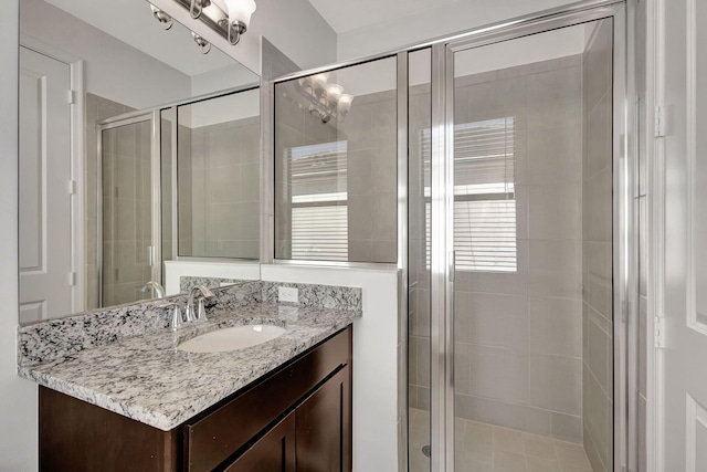 bathroom featuring vanity and a shower with shower door