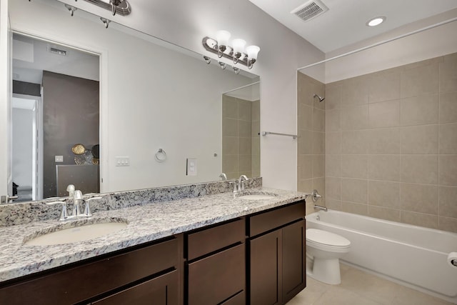 full bathroom featuring tile patterned flooring, vanity, tiled shower / bath combo, and toilet