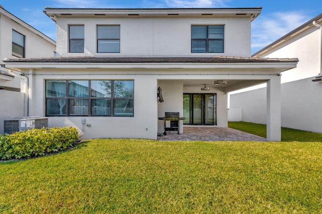 rear view of house with a lawn, a patio, and central AC unit