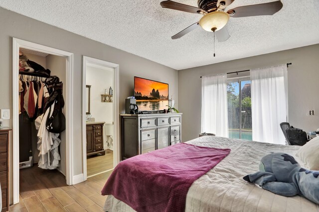 bedroom featuring a textured ceiling, connected bathroom, and ceiling fan