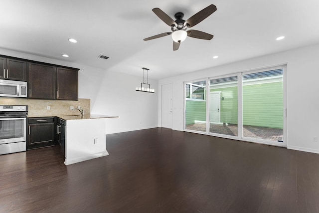 kitchen with decorative light fixtures, dark hardwood / wood-style floors, ceiling fan, stainless steel appliances, and decorative backsplash